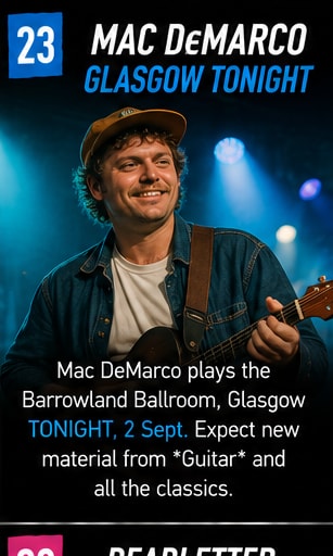 Mac DeMarco smiling with acoustic guitar on stage under concert lights.