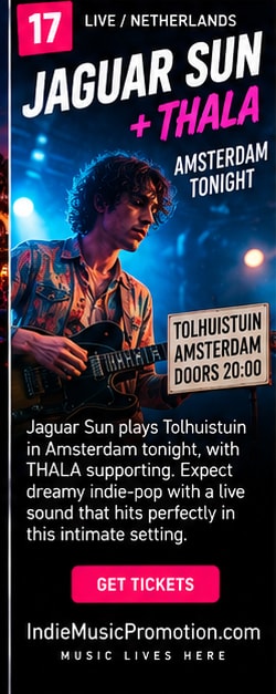 Guitarist performing under bright warm stage lights for Jaguar Sun concert.