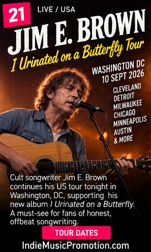 Jim E. Brown singing with acoustic guitar under warm stage lighting.
