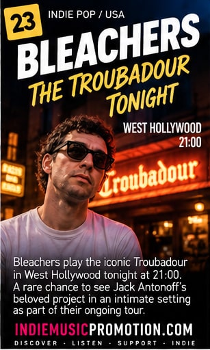 Jack Antonoff of Bleachers wearing sunglasses outside the neon-lit Troubadour marquee in West Hollywood.