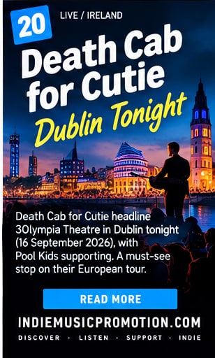 Musician with acoustic guitar silhouetted against illuminated Dublin River Liffey cityscape at night.
