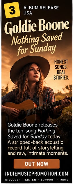 Goldie Boone with acoustic guitar in rural golden hour field for Nothing Saved for Sunday.