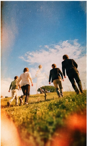 Silk Road musicians walking together up a sun-drenched grassy hill toward a clear blue horizon.