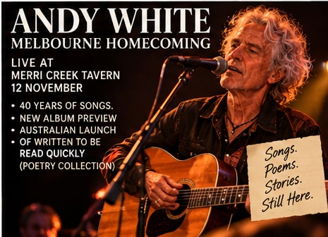 Northern Irish songwriter and poet Andy White singing passionately into a stage microphone while playing acoustic guitar.